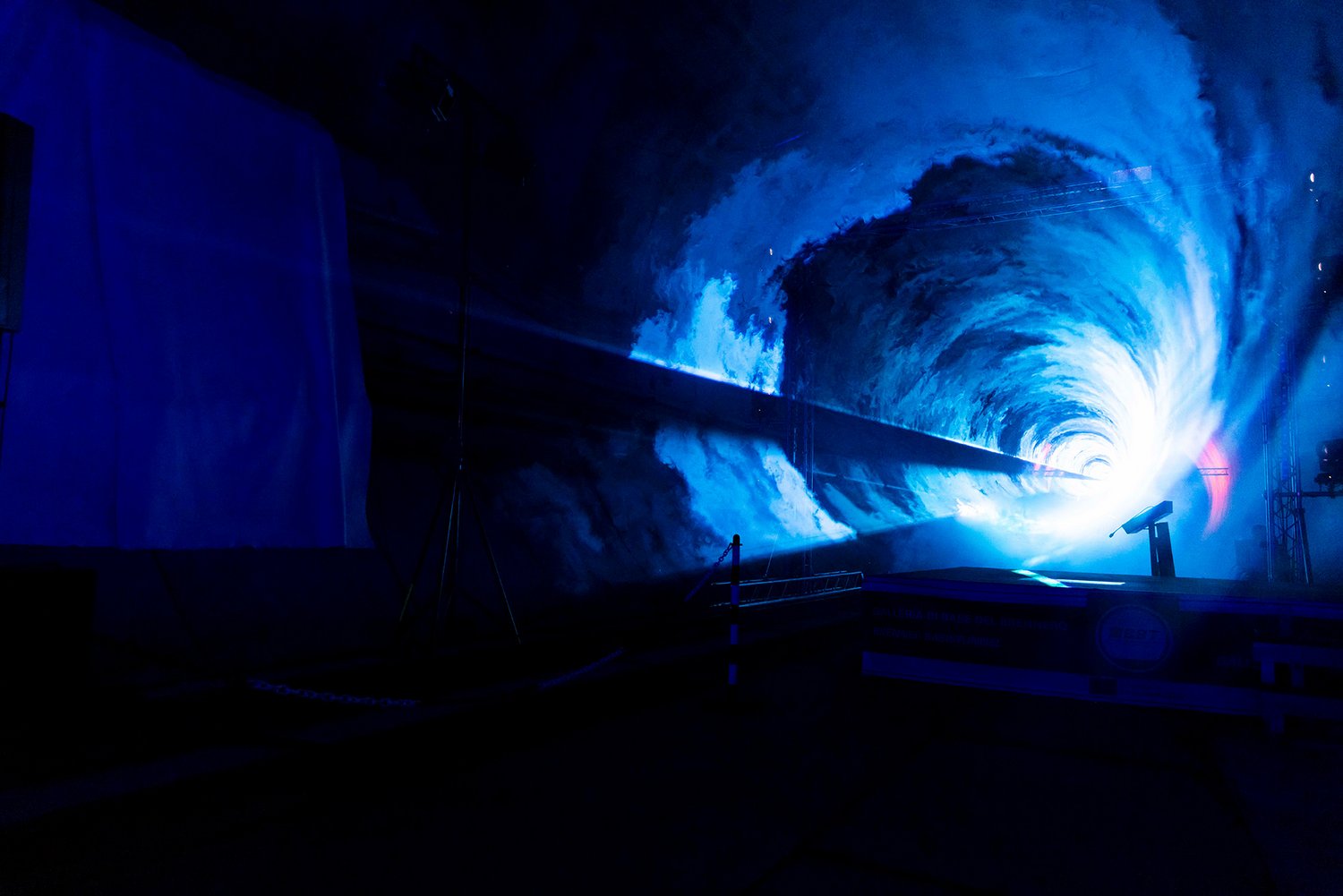 Ein Foto vom Abschluss des maschinellen Tunnelvortriebs in Italien. Die Tunnelröhre wird durch Lichteffekte in Szene gesetzt.